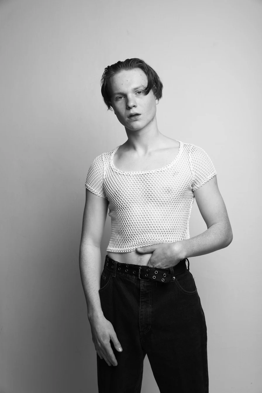 Model in dunkler Weste und weiter Hose