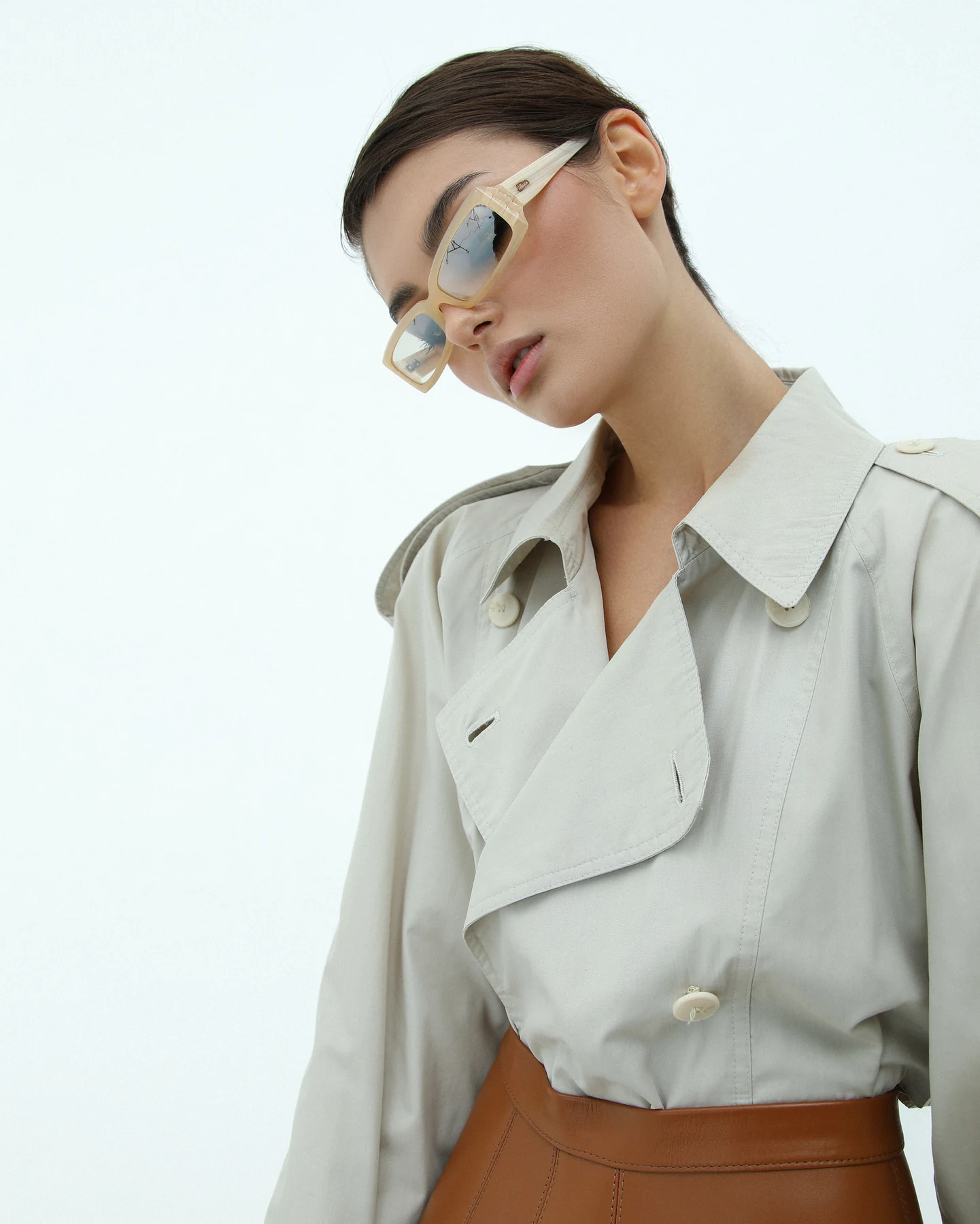 Model mit Sonnenbrille und hellem Trenchcoat